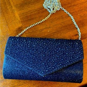 Sparkling clutch purse with detachable chain. Measures approx 7.5 x 5.0.